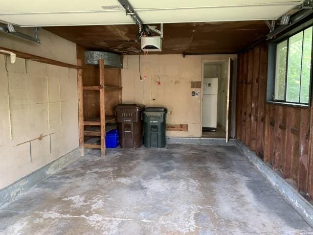 323 Windsor St, Park Forest, IL 60466 - garage featuring freestanding refrigerator, a garage door opener, and wooden walls
