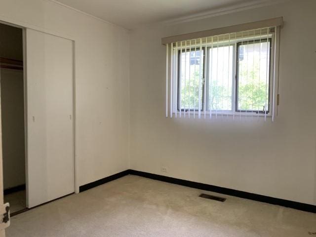 323 Windsor St, Park Forest, IL 60466 - unfurnished bedroom featuring a closet, light colored carpet, and baseboards