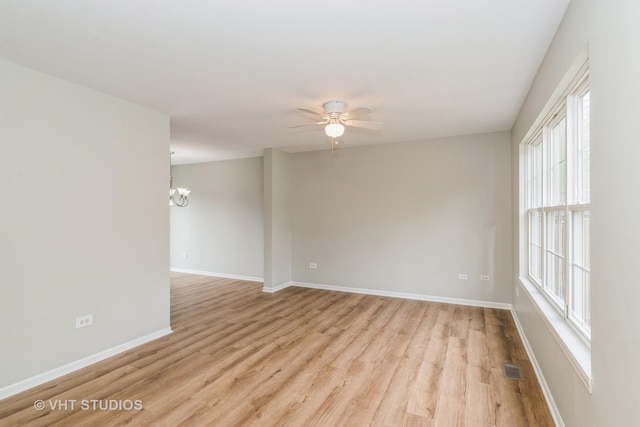 25785 W Hillside Ave, Ingleside, IL 60041 - spare room with light wood-type flooring, a chandelier, a ceiling fan, and baseboards