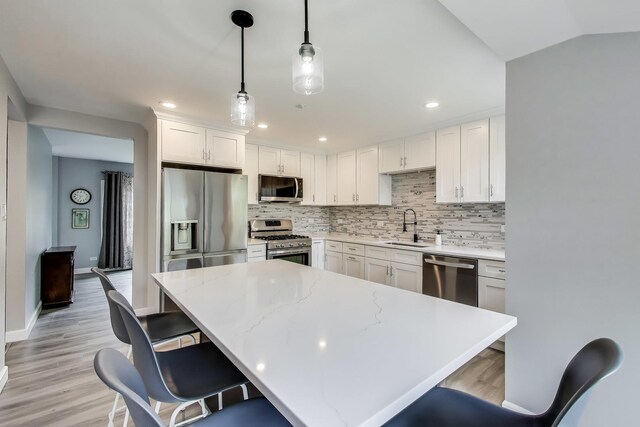 3205 Meadow Dr, Rolling Meadows, IL 60008 - kitchen with appliances with stainless steel finishes, a sink, decorative backsplash, a breakfast bar area, and recessed lighting