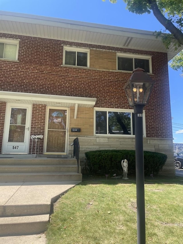 549 E Lincoln St Unit 549, Mount Prospect, IL 60056 - view of front of property with a front yard, stone siding, and brick siding