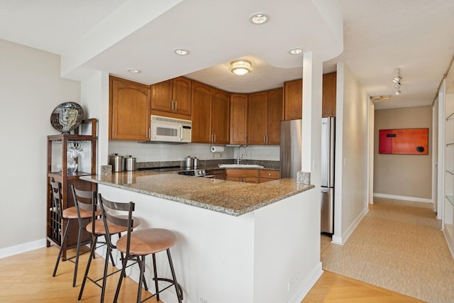 405 N Wabash Ave Unit 3103, Chicago, IL 60611 - kitchen featuring freestanding refrigerator, white microwave, a sink, baseboards, and brown cabinets