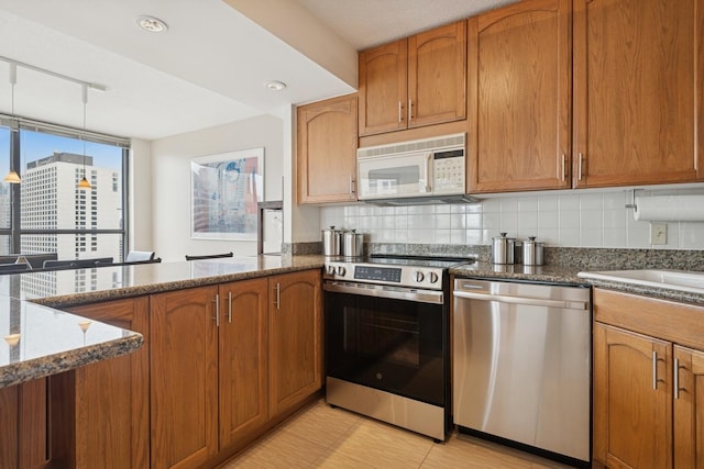 405 N Wabash Ave Unit 3103, Chicago, IL 60611 - kitchen with stainless steel appliances, dark stone counters, tasteful backsplash, and brown cabinets