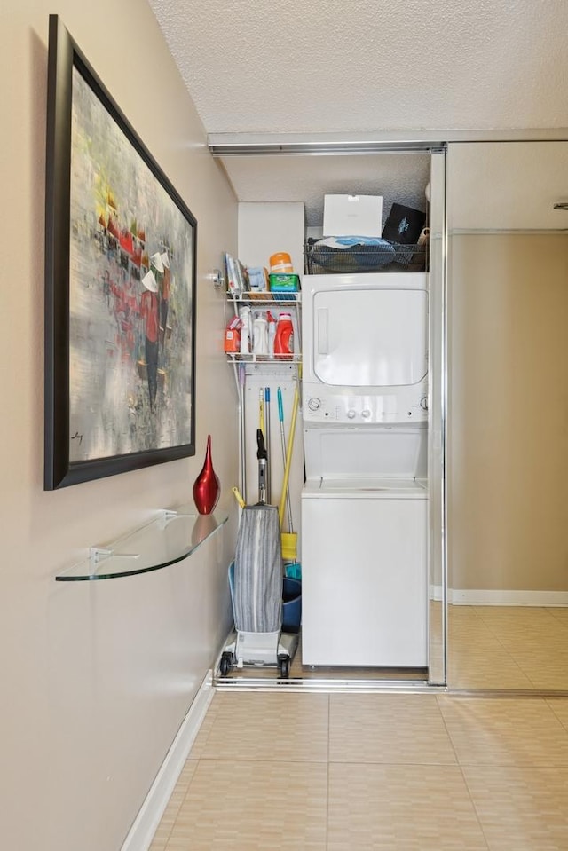 405 N Wabash Ave Unit 3103, Chicago, IL 60611 - washroom featuring estacked washer and dryer, baseboards, tile patterned floors, and a textured ceiling