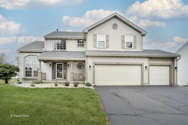 2012 Spring Creek Ln, Mchenry, IL 60050 - traditional home featuring covered porch, a front lawn, asphalt driveway, roof with shingles, and a garage