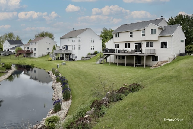 2012 Spring Creek Ln, Mchenry, IL 60050 - back of property featuring stairs, a deck with water view, a lawn, and a residential view