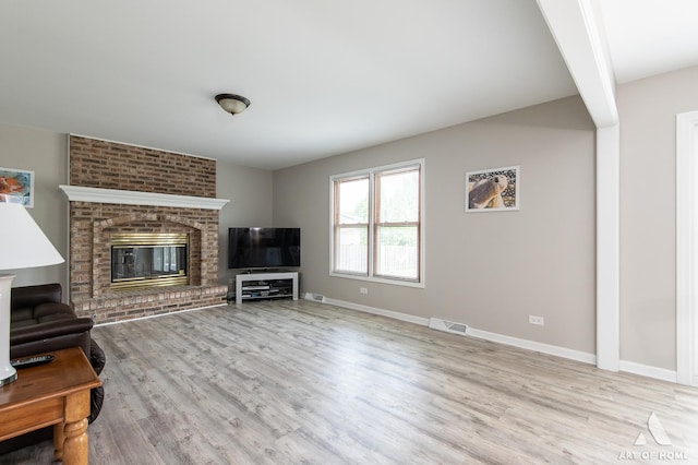 3365 Charlemaine Dr, Aurora, IL 60504 - unfurnished living room featuring wood finished floors, baseboards, a brick fireplace, and beam ceiling