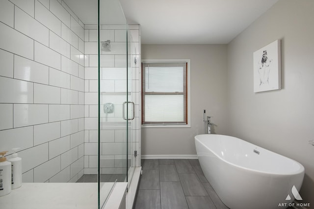 3365 Charlemaine Dr, Aurora, IL 60504 - full bathroom featuring a shower stall, a freestanding tub, and baseboards
