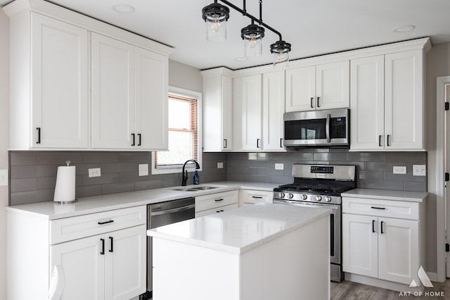 3365 Charlemaine Dr, Aurora, IL 60504 - kitchen featuring appliances with stainless steel finishes, a sink, white cabinetry, and a kitchen island