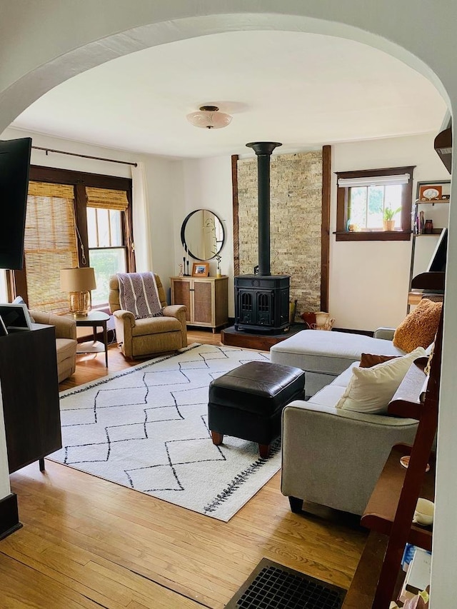 106 Dewey St, Harvard, IL 60033 - living room with arched walkways, a wood stove, and light wood-style flooring