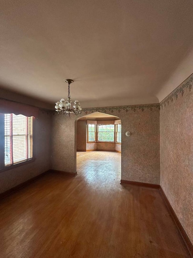 402 N NW Hwy, Park Ridge, IL 60068 - spare room with arched walkways, wood finished floors, a chandelier, and baseboards