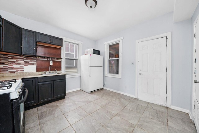5014 S Paulina St, Chicago, IL 60609 - kitchen featuring freestanding refrigerator, a sink, gas range, tasteful backsplash, and light countertops