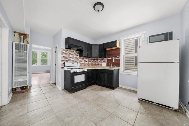 5014 S Paulina St, Chicago, IL 60609 - kitchen featuring freestanding refrigerator, range with gas cooktop, a heating unit, light countertops, and decorative backsplash