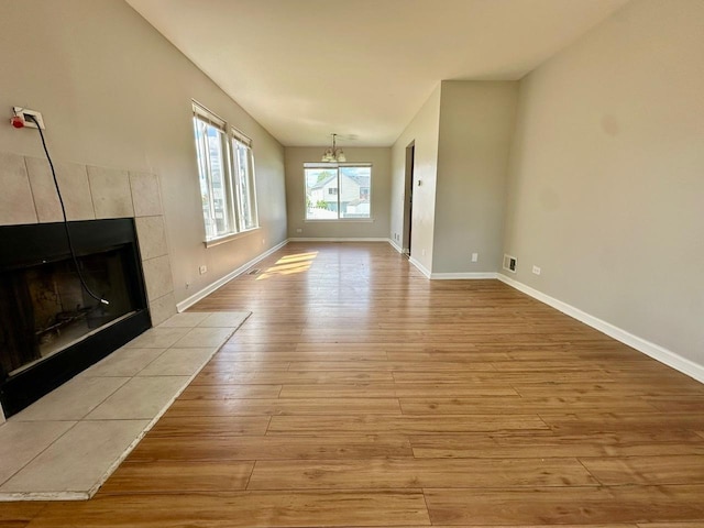 1458 Woodland Dr, South Elgin, IL 60177 - unfurnished living room with hardwood / wood-style floors, a chandelier, a tile fireplace, and baseboards