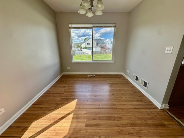 1458 Woodland Dr, South Elgin, IL 60177 - unfurnished dining area featuring a chandelier, hardwood / wood-style flooring, and baseboards