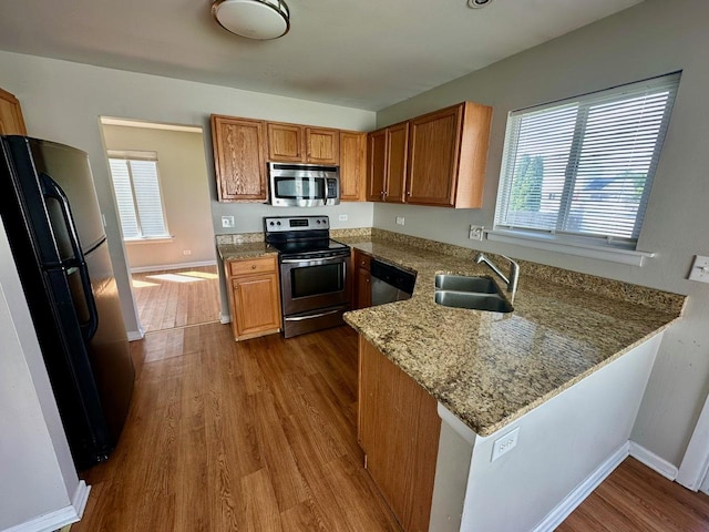 1458 Woodland Dr, South Elgin, IL 60177 - kitchen featuring appliances with stainless steel finishes, dark wood finished floors, a peninsula, a sink, and light stone counters