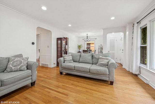 5513 Mulford St, Skokie, IL 60077 - living room with arched walkways, light wood-style floors, a chandelier, baseboards, and recessed lighting