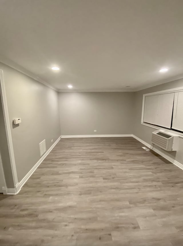 501 E Prospect Ave Unit 1F, Mount Prospect, IL 60056 - below grade area with crown molding, a wall mounted AC, baseboards, recessed lighting, and wood finished floors