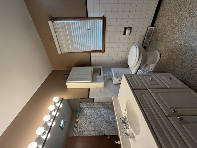 612 S 1st Ave, Forreston, IL 61030 - bathroom featuring toilet, tile walls, washer / clothes dryer, and decorative backsplash