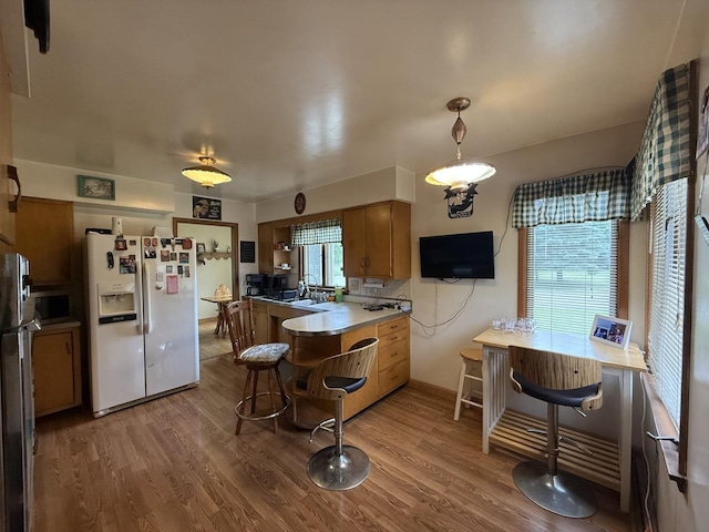 612 S 1st Ave, Forreston, IL 61030 - kitchen with white fridge with ice dispenser, a peninsula, wood finished floors, fridge, and a sink