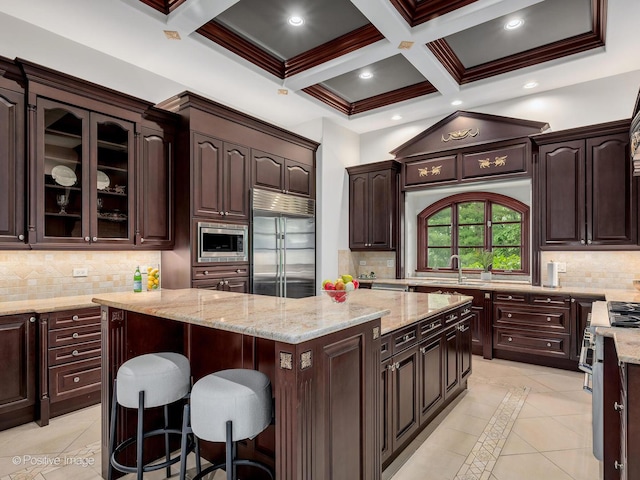 11315 77th St, Burr Ridge, IL 60527 - kitchen with built in appliances, a kitchen island, a breakfast bar area, beamed ceiling, and backsplash