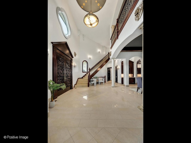 11315 77th St, Burr Ridge, IL 60527 - foyer entrance with decorative columns, arched walkways, a towering ceiling, stairway, and tile patterned floors