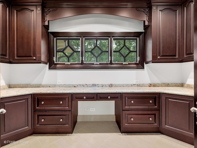 11315 77th St, Burr Ridge, IL 60527 - kitchen with built in study area, dark brown cabinetry, light tile patterned flooring, and light stone counters