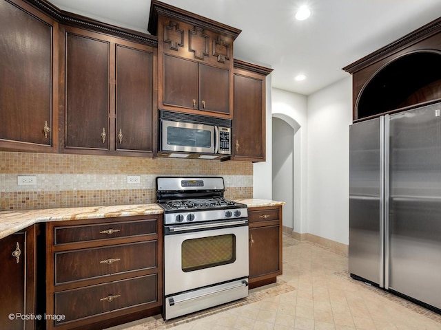 11315 77th St, Burr Ridge, IL 60527 - kitchen with stainless steel appliances, backsplash, arched walkways, dark brown cabinetry, and recessed lighting
