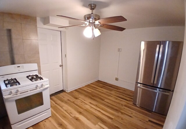 254 E 92nd St, Chicago, IL 60619 - kitchen with white gas range oven, freestanding refrigerator, light wood-style floors, a ceiling fan, and baseboards
