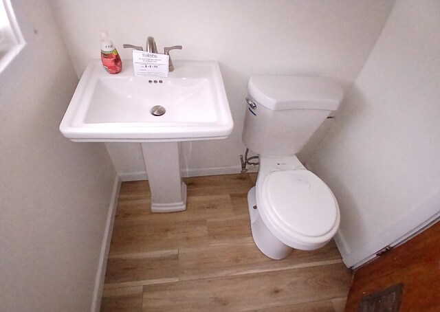 254 E 92nd St, Chicago, IL 60619 - bathroom with wood finished floors, toilet, a sink, and baseboards