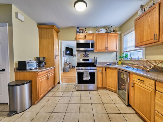 7314 W 58th St, Summit, IL 60501 - kitchen with appliances with stainless steel finishes, wine cooler, light tile patterned flooring, a sink, and brown cabinetry