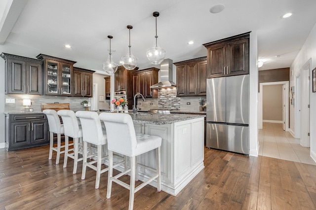 7166 Clubhouse Dr, Yorkville, IL 60560 - kitchen featuring stainless steel appliances, wall chimney exhaust hood, a sink, tasteful backsplash, and dark brown cabinets