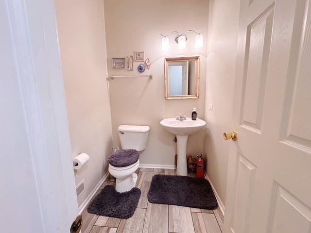 11319 Maplewood Dr, Plainfield, IL 60585 - bathroom with toilet, wood finished floors, baseboards, and a sink