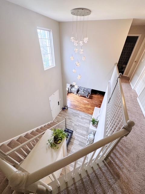 11319 Maplewood Dr, Plainfield, IL 60585 - stairs featuring a chandelier