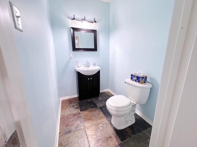 11319 Maplewood Dr, Plainfield, IL 60585 - bathroom with stone tile floors, toilet, vanity, and baseboards