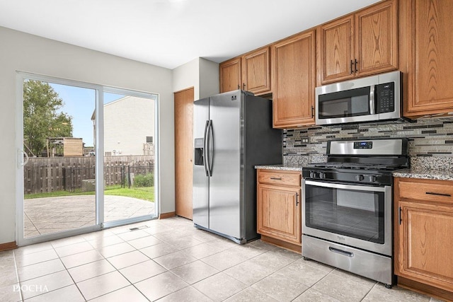 2413 Roxbury Ln, Montgomery, IL 60538 - kitchen with stainless steel appliances, backsplash, brown cabinetry, and light tile patterned floors