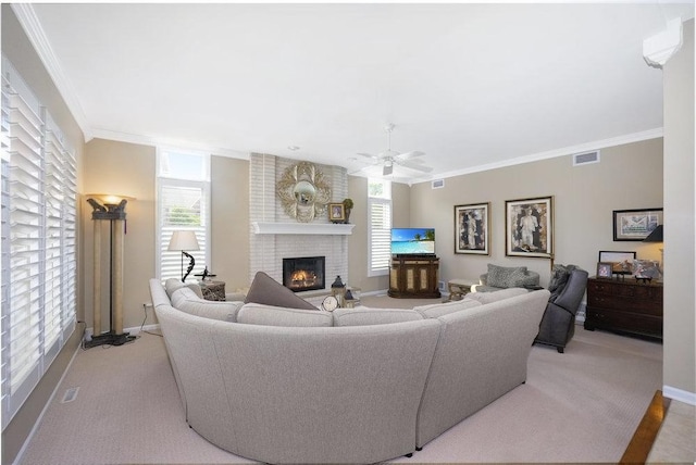 1537 Monarch Cir, Naperville, IL 60564 - living room with a brick fireplace, plenty of natural light, ornamental molding, a ceiling fan, and baseboards