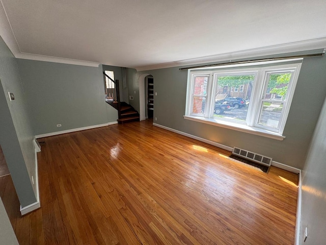 6649 S Karlov Ave, Chicago, IL 60629 - empty room featuring arched walkways, wood finished floors, baseboards, crown molding, and stairs