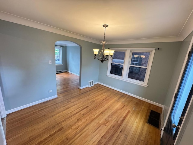 6649 S Karlov Ave, Chicago, IL 60629 - unfurnished dining area with arched walkways, a chandelier, wood finished floors, baseboards, and crown molding