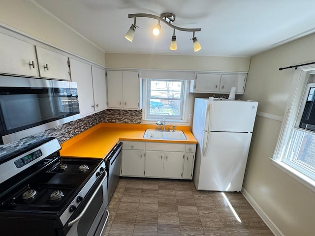 6649 S Karlov Ave, Chicago, IL 60629 - kitchen with appliances with stainless steel finishes, a sink, white cabinets, and backsplash