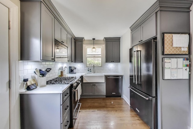 9906 S Saint Louis Ave, Evergreen Park, IL 60805 - kitchen with stainless steel appliances, a sink, gray cabinets, wood finished floors, and tasteful backsplash