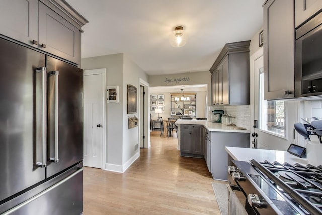 9906 S Saint Louis Ave, Evergreen Park, IL 60805 - kitchen with appliances with stainless steel finishes, gray cabinetry, light countertops, decorative backsplash, and light wood-style flooring