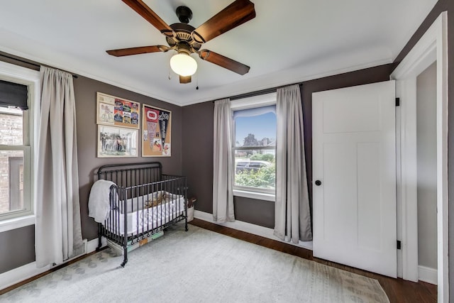 9906 S Saint Louis Ave, Evergreen Park, IL 60805 - bedroom featuring baseboards, a crib, wood finished floors, and a ceiling fan