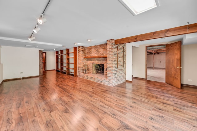 24721 S Walnut St, Crete, IL 60417 - unfurnished living room featuring wood finished floors, baseboards, a brick fireplace, and track lighting