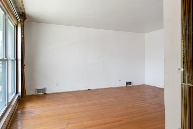 8952 S E End Ave, Chicago, IL 60617 - empty room featuring wood finished floors, healthy amount of natural light, and baseboards