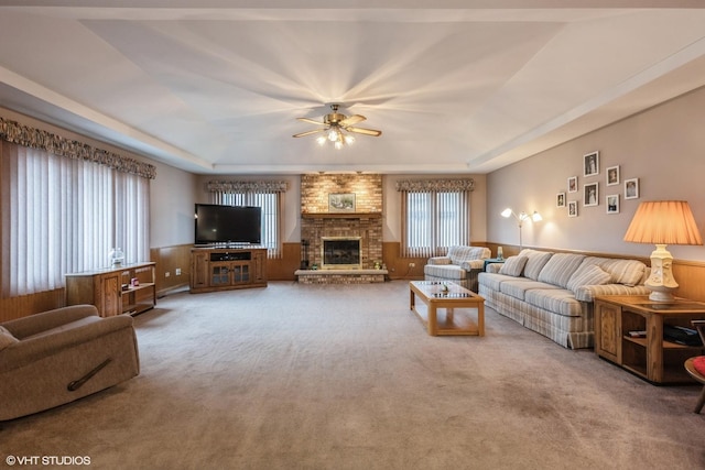 19510 Blyth Way, Mokena, IL 60448 - living area featuring a raised ceiling, a ceiling fan, carpet flooring, a brick fireplace, and wainscoting