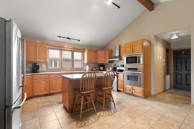 8542 Monaghan Dr, Tinley Park, IL 60487 - kitchen featuring appliances with stainless steel finishes, wall chimney exhaust hood, rail lighting, light tile patterned flooring, and a center island