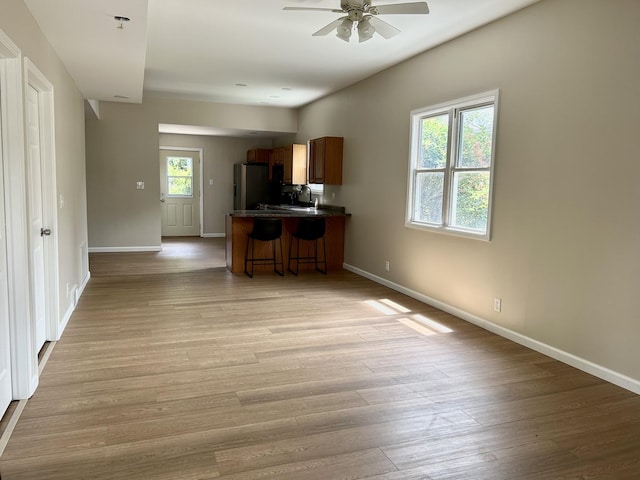 123 N Chicago Ave, Ladd, IL 61329 - kitchen with a ceiling fan, a kitchen breakfast bar, baseboards, dark countertops, and a peninsula