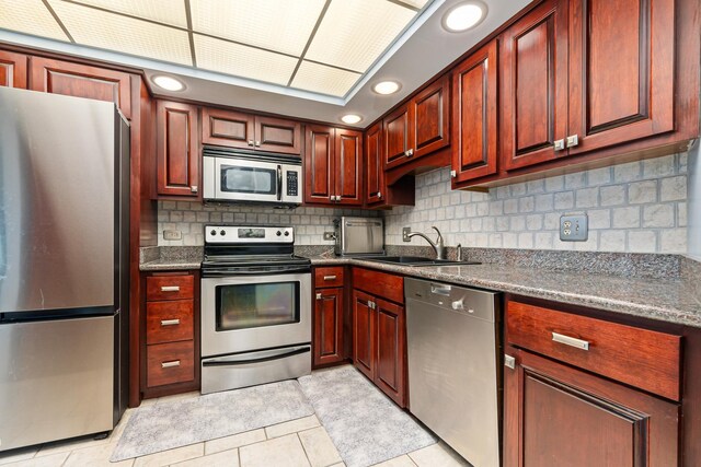 825 Center St Unit 302, Des Plaines, IL 60016 - kitchen with stainless steel appliances, a sink, tasteful backsplash, light tile patterned flooring, and dark brown cabinets