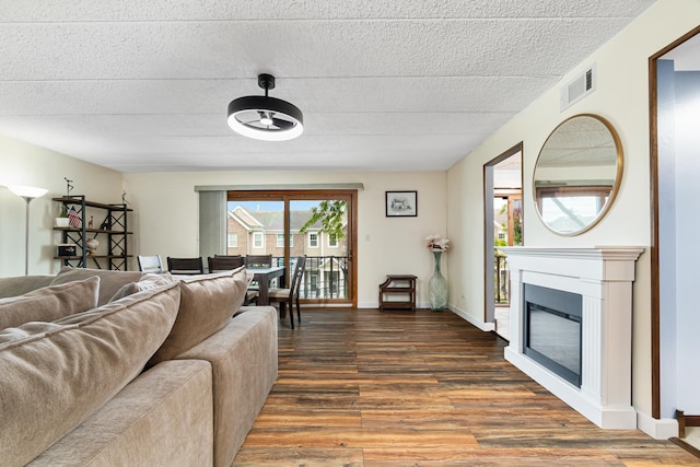825 Center St Unit 302, Des Plaines, IL 60016 - living area featuring wood finished floors, a glass covered fireplace, baseboards, and a textured ceiling